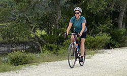 Kathy Hogan Edwards rides her bike on a nature trail
